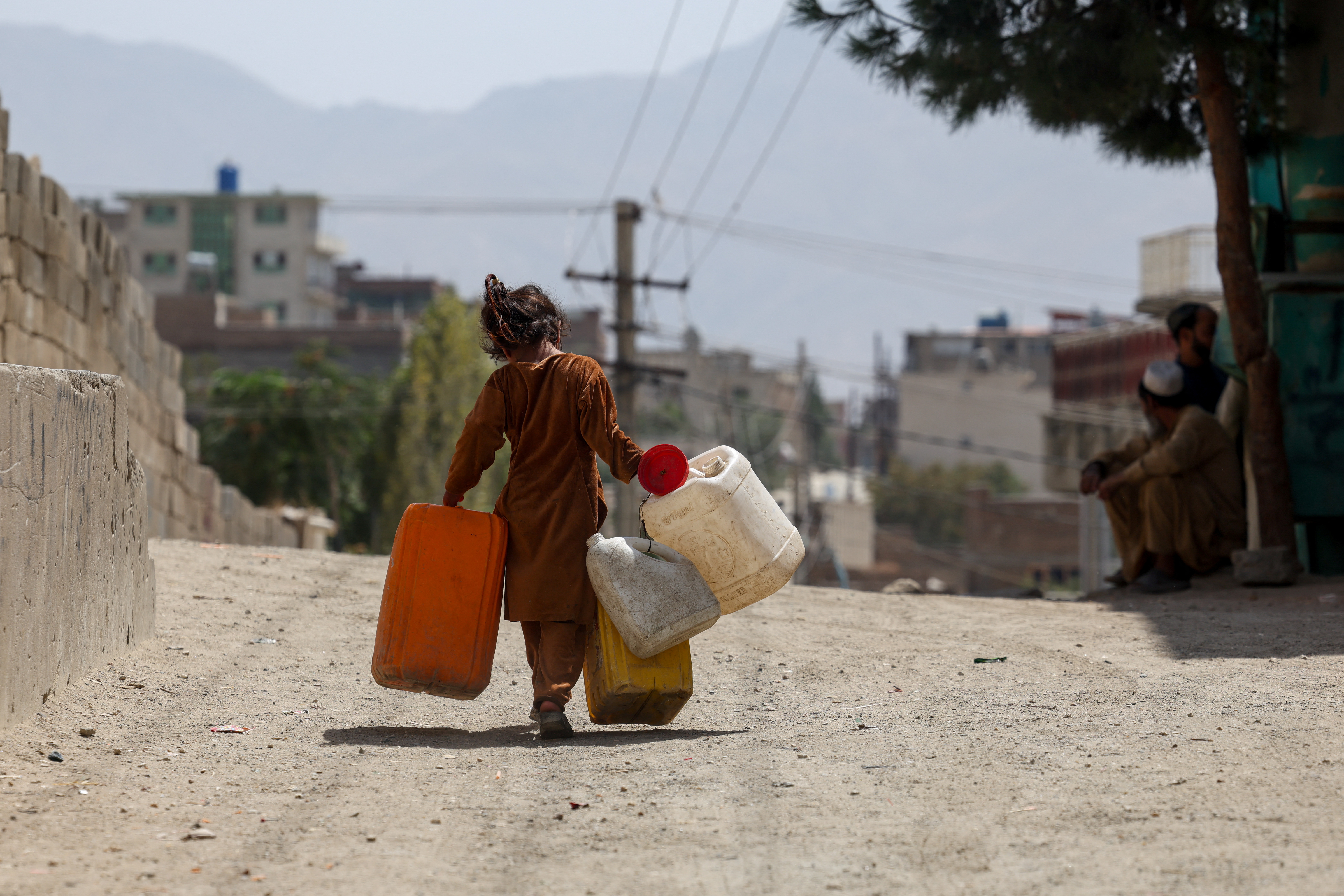 A girl carries empty barrels to fetch water, amid serious water crisis in Kabul, Afghanistan, August 28, 2025. 