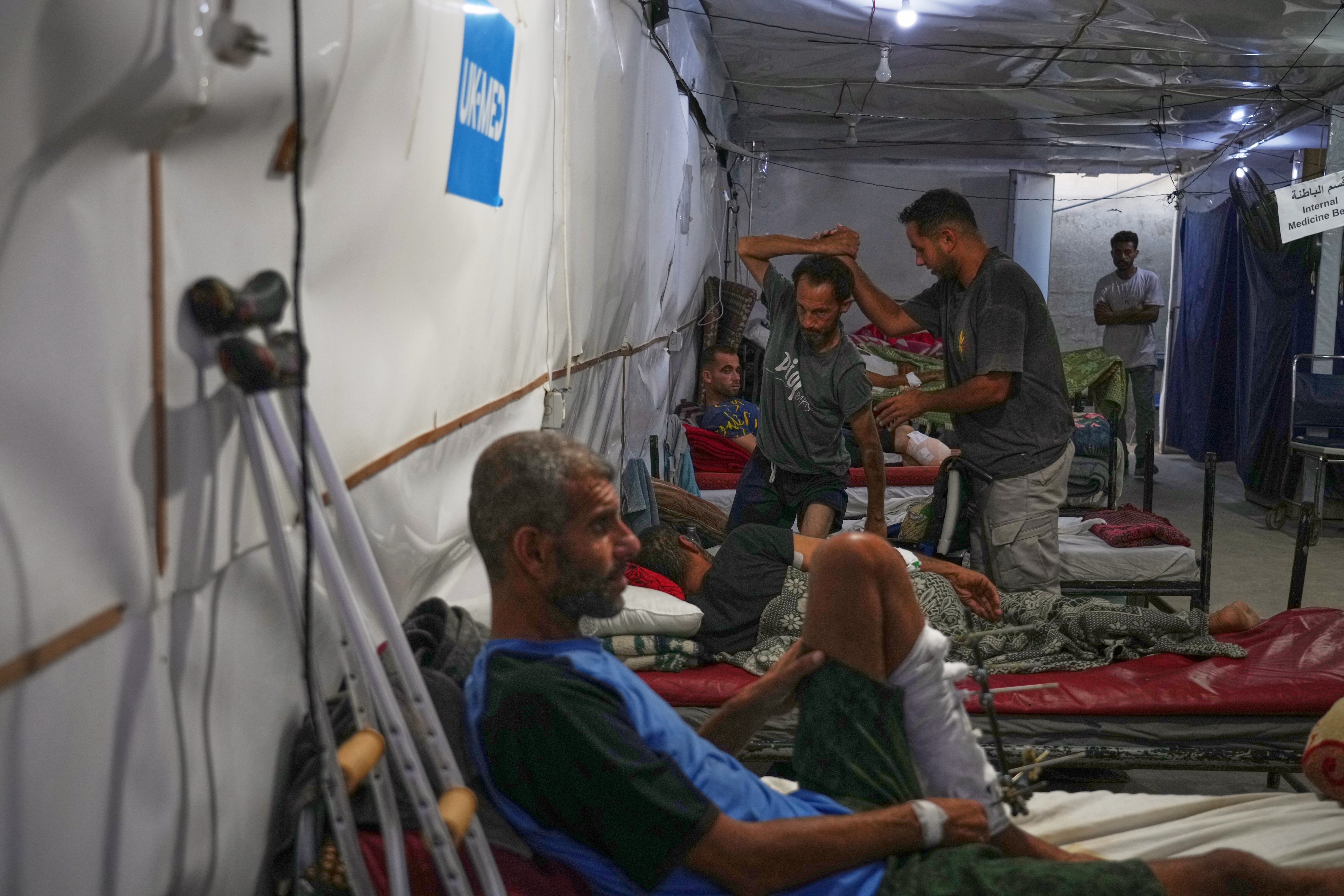Dr. Paul Ransom of the British humanitarian medical NGO UK-Med, assisted by local medical staff, treats patients at a field hospital in Muwasi, near Khan Younis. (AP)