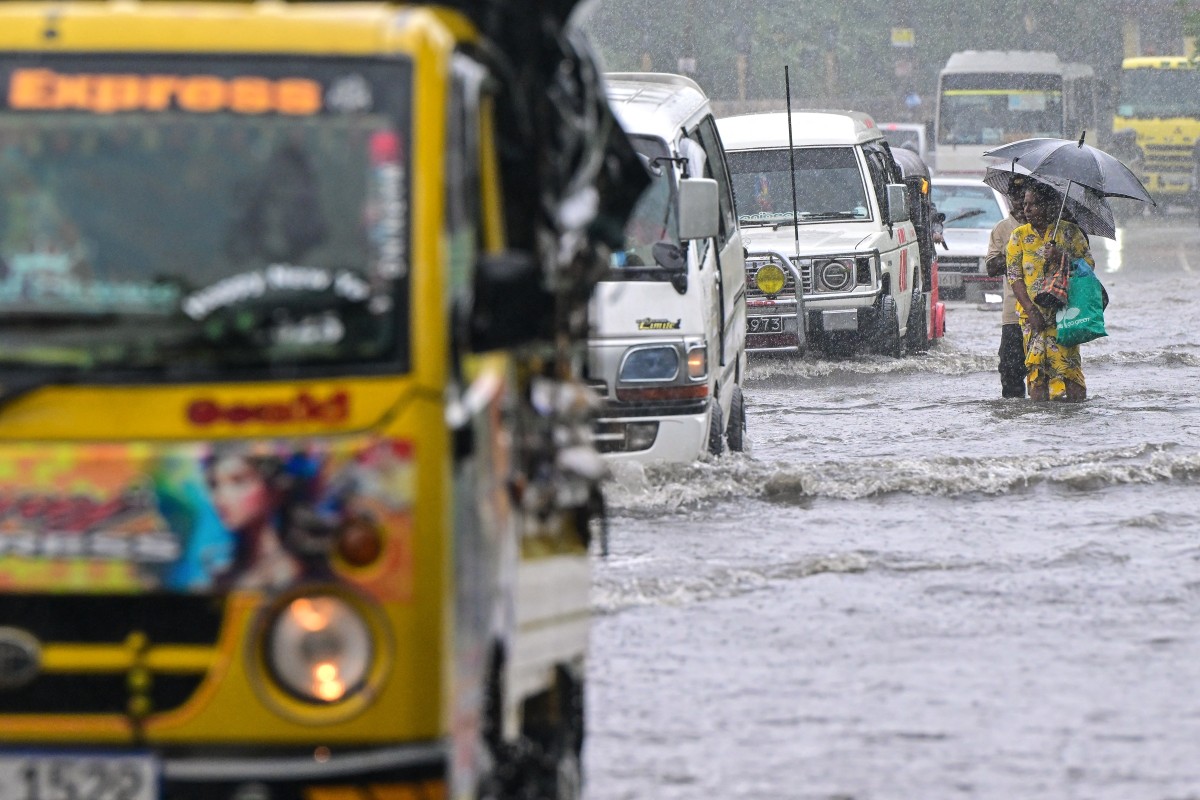 People wade through a flooded road in Biyagama, on the outskirts of Colombo on November 28, 2025.(AFP)