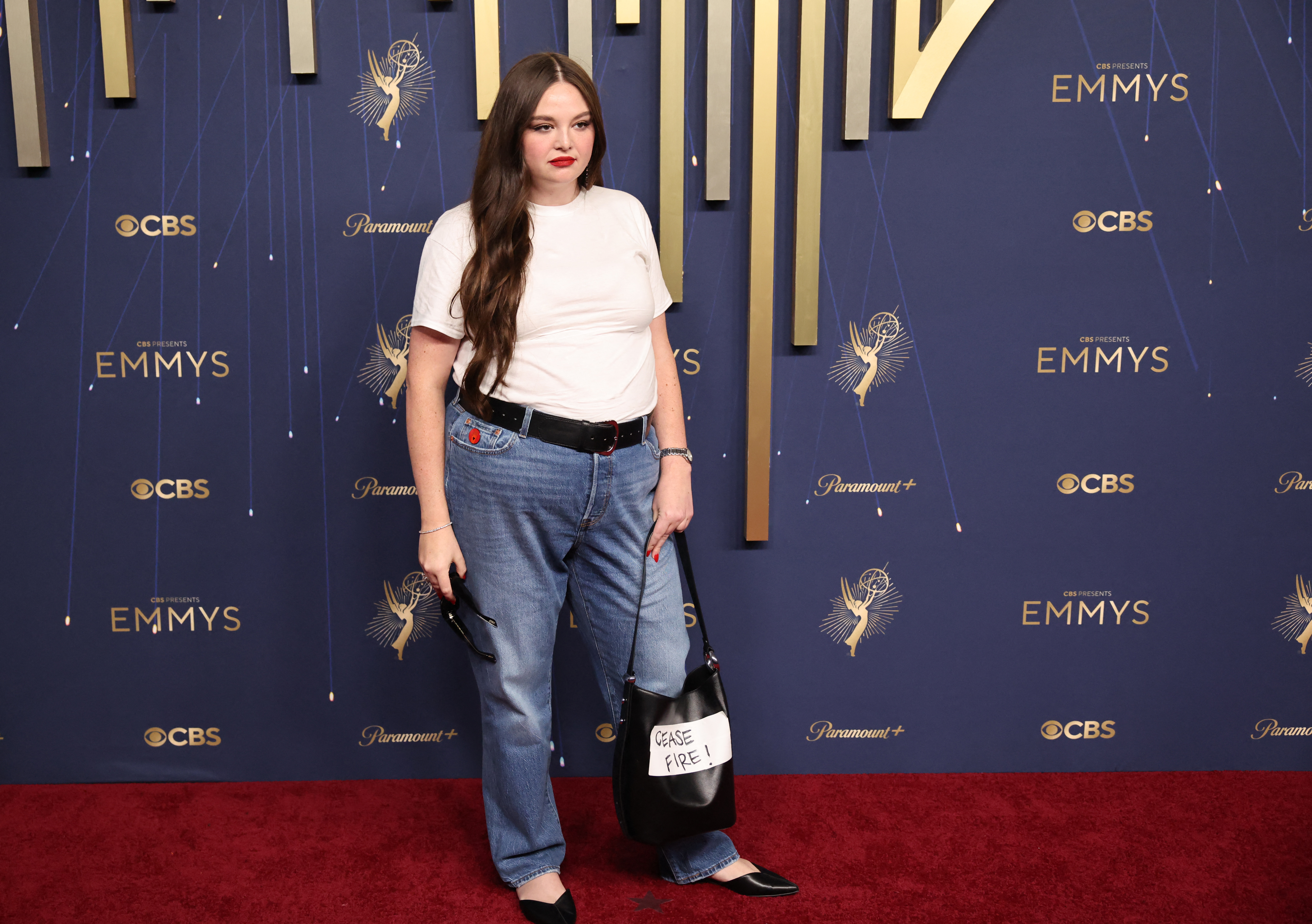 Megan Stalter holds a bag with a "Cease fire" message as she poses on the red carpet at the 77th Primetime Emmy Awards in Los Angeles, California, U.S., September 14, 2025. REUTERS/Daniel Cole