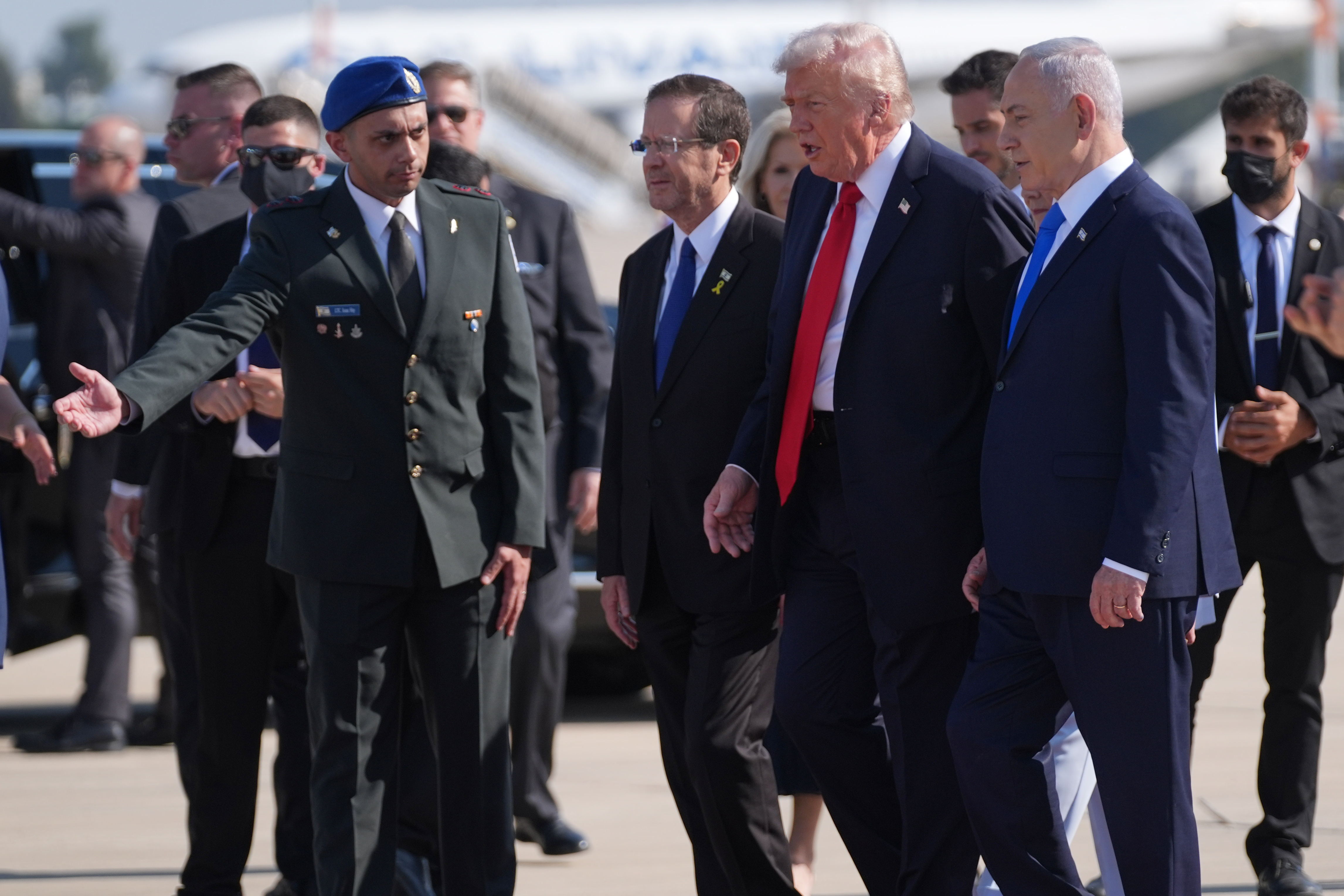 President Donald Trump walks with Israel's President Isaac Herzog, left, and Israel's Prime Minister Benjamin Netanyahu during an arrival ceremony at Ben Gurion International Airport, Monday, Oct. 13, 2025, near Tel Aviv. (AP Photo/Evan Vucci)