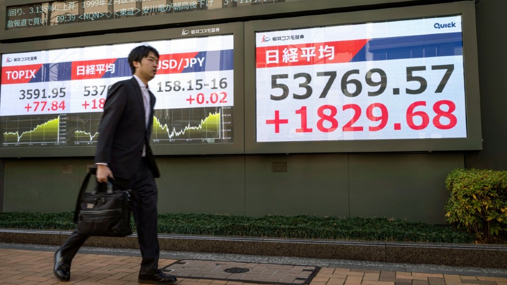 TOKYO: A man walks past an electronic quotation board displaying numbers of the Nikkei Stock Average (R) on the Tokyo Stock Exchange in Tokyo on January 13, 2026. (File Photo by AFP/Kazuhiro Nogi)