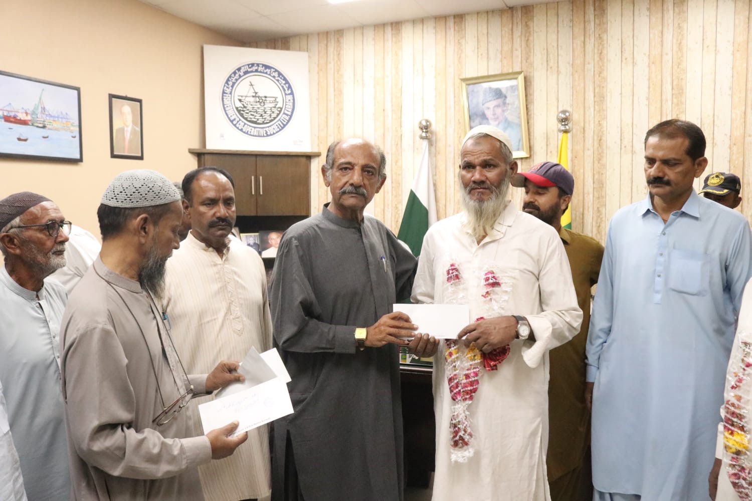 Pakistani fishermen receive cheques following their return to Karachi after years of detention in Indian jails.