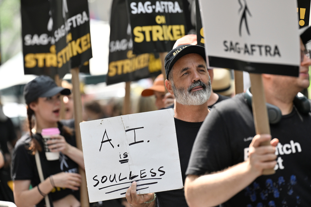 SAG-AFTRA picketers carry signs outside NBC in Rockefeller Center on July 17, 2023, in New York.