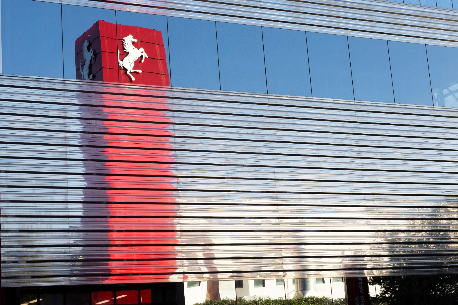 A Ferrari logo is reflected on the external wall of the company's factory in Maranello, Italy, October 2, 2025. (REUTERS)