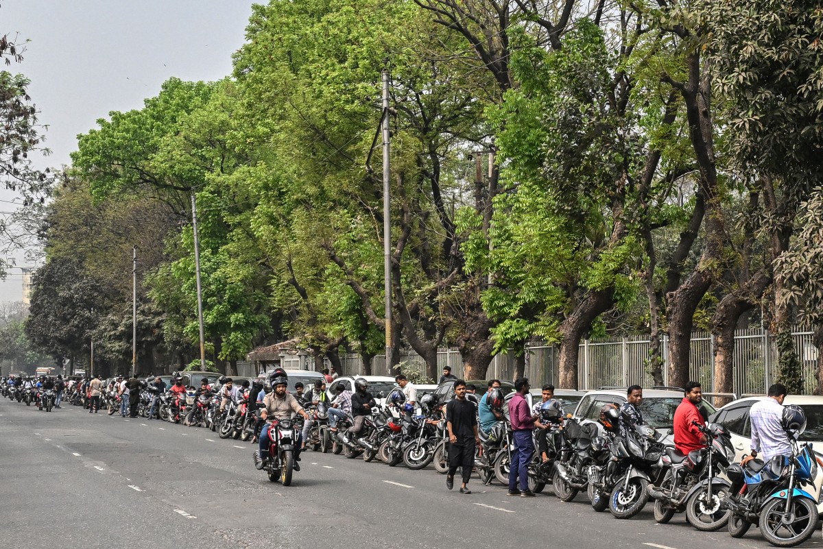 People wait in a queue to refuel their vehicles near a fuel station in Dhaka on March 8, 2026