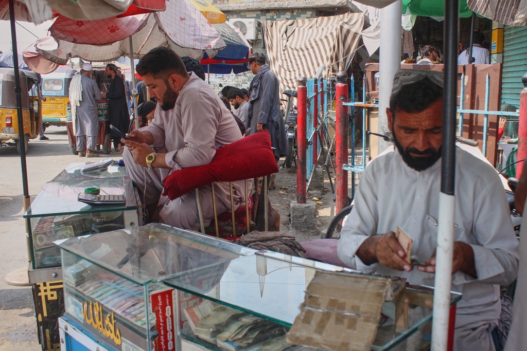 A man at a street stand for money exchange checks his cellphone after some networks were restored following an outage that began Monday in Jalalabad, Afghanistan, Wednesday, Oct. 1, 2025. (AP)