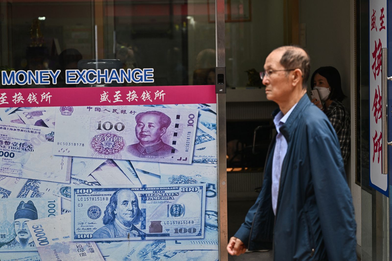 This picture taken on May 28, 2025 shows a man walking past a currency exchange in Seoul's Daerim neighborhood, home to thousands of ethnic Chinese. (AFP/File)