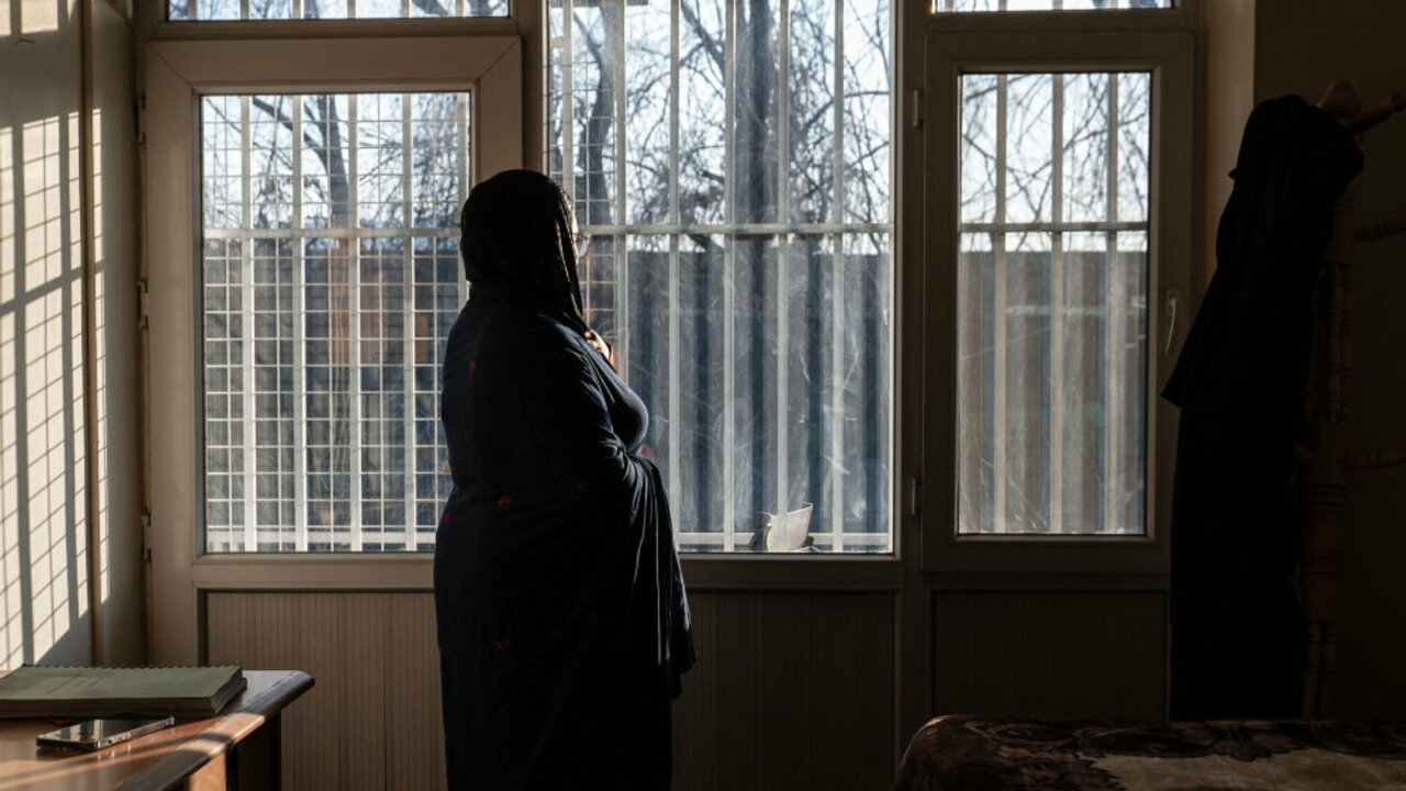 This photograph taken on February 17, 2026 shows an Afghan hospital medic, who studied public relations and journalism before universities were closed to women, standing next to a window inside a house in Afghanistan. (AFP)