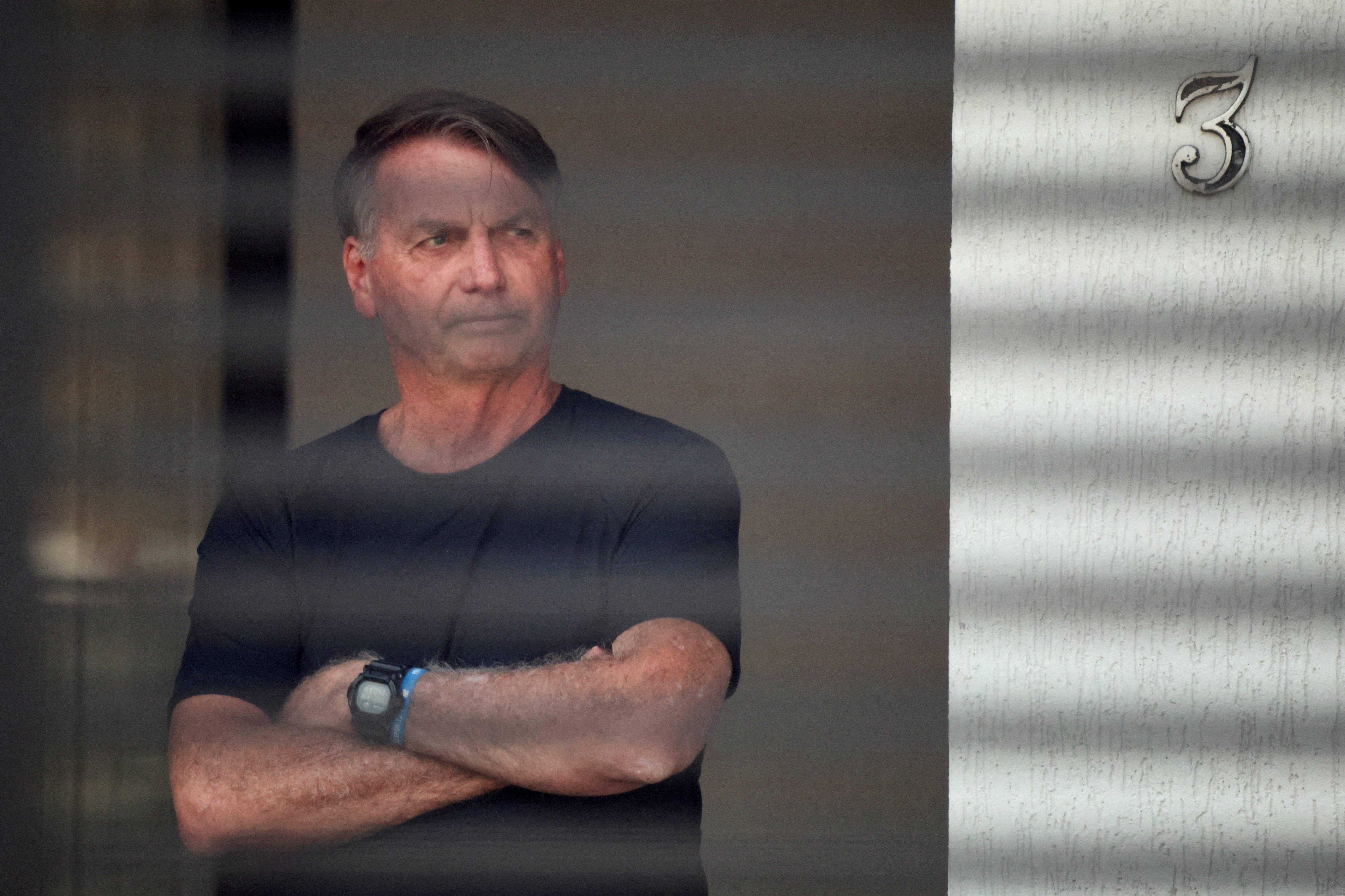  Brazil's former President Jair Bolsonaro stands at his home while under house arrest