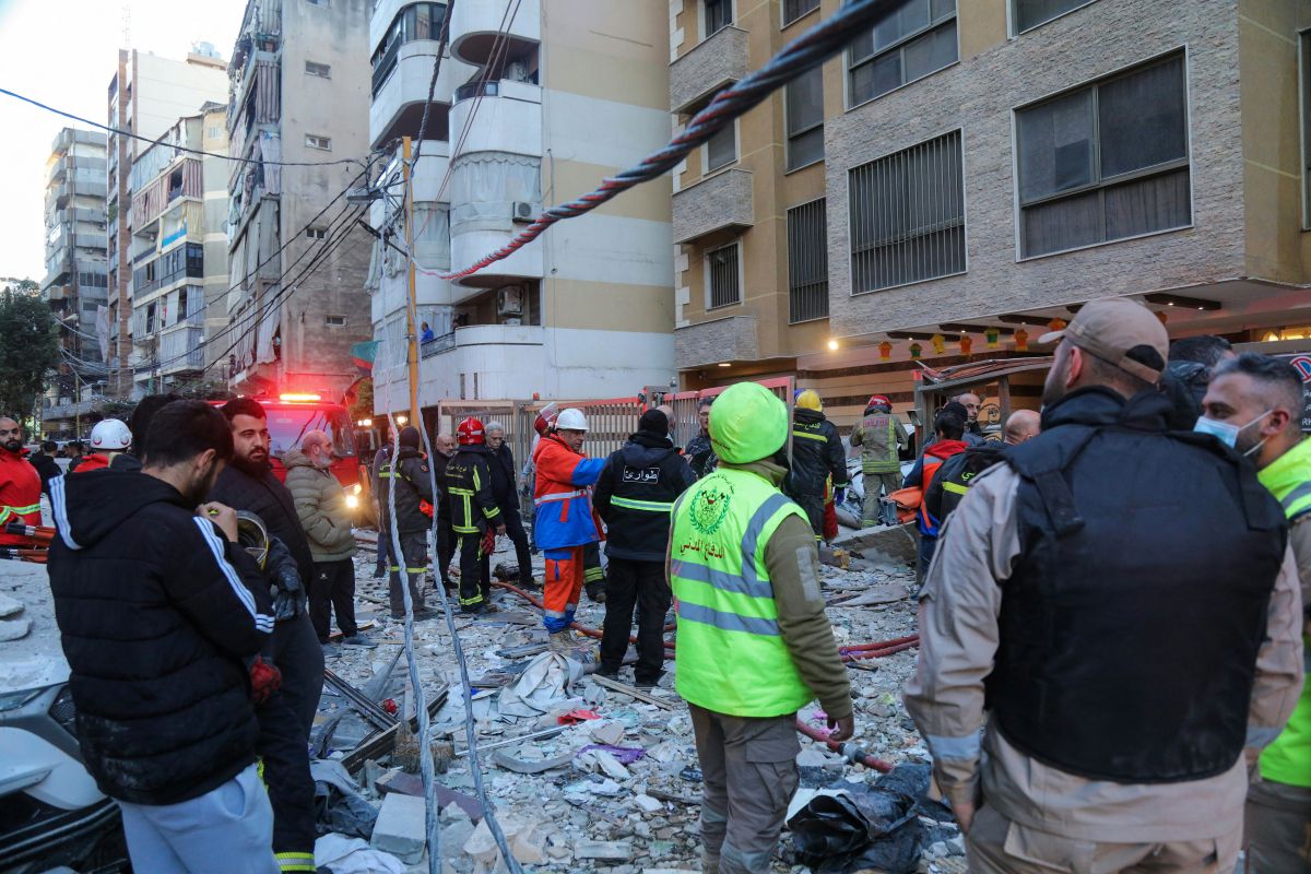 Emergency personnel and residents gather at the site of an Israeli airstrike that targeted a building in the Aisha Bakkar neighborhood of Beirut on March 11, 2026. (AFP)