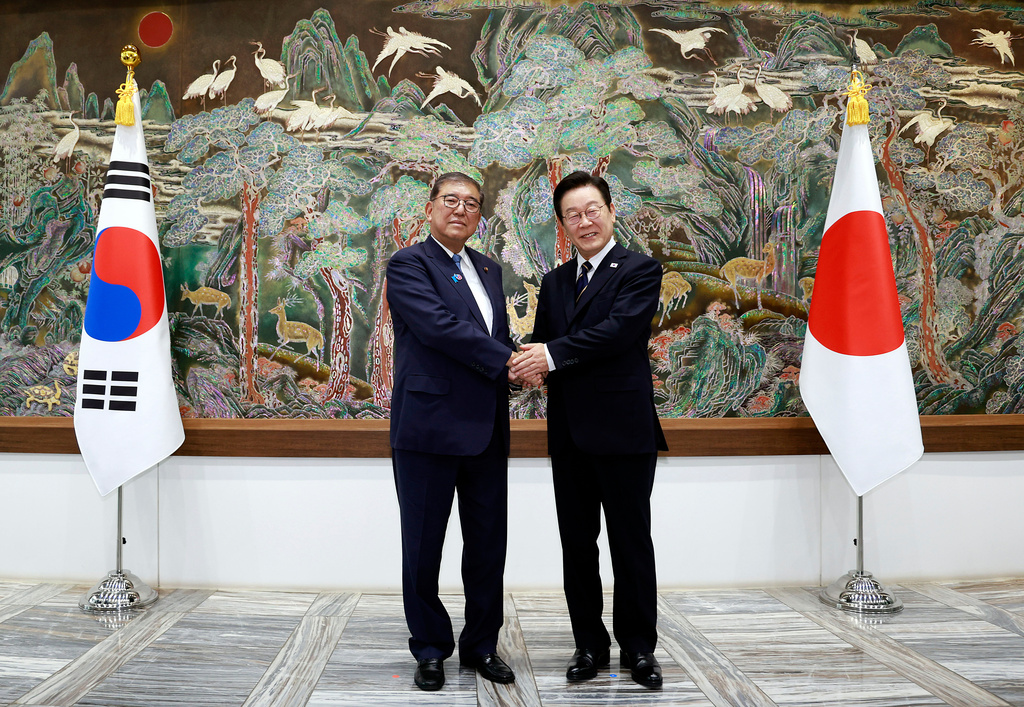 South Korean President Lee Jae Myung, right, shakes hands with Japanese Prime Minister Shigeru Ishiba during a meeting in Busan, South Korea