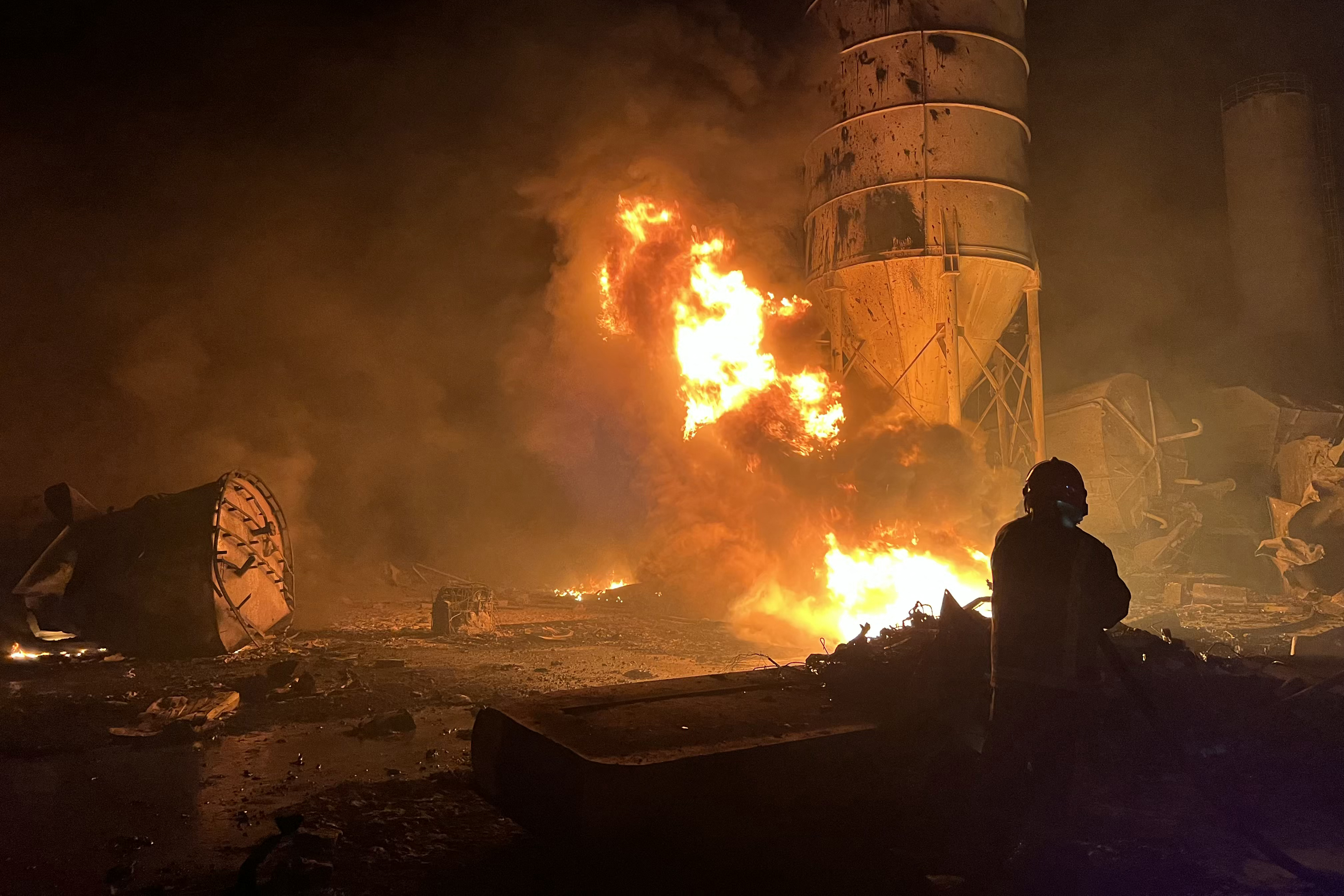A firefighter douses flames at a cement factory after Israeli airstrikes in Ansar, near Doueir, southern Lebanon, on Oct. 16, 2025. Lebanon’s Health Ministry said the strikes killed one person and wounded seven. (AP Photo/Name)