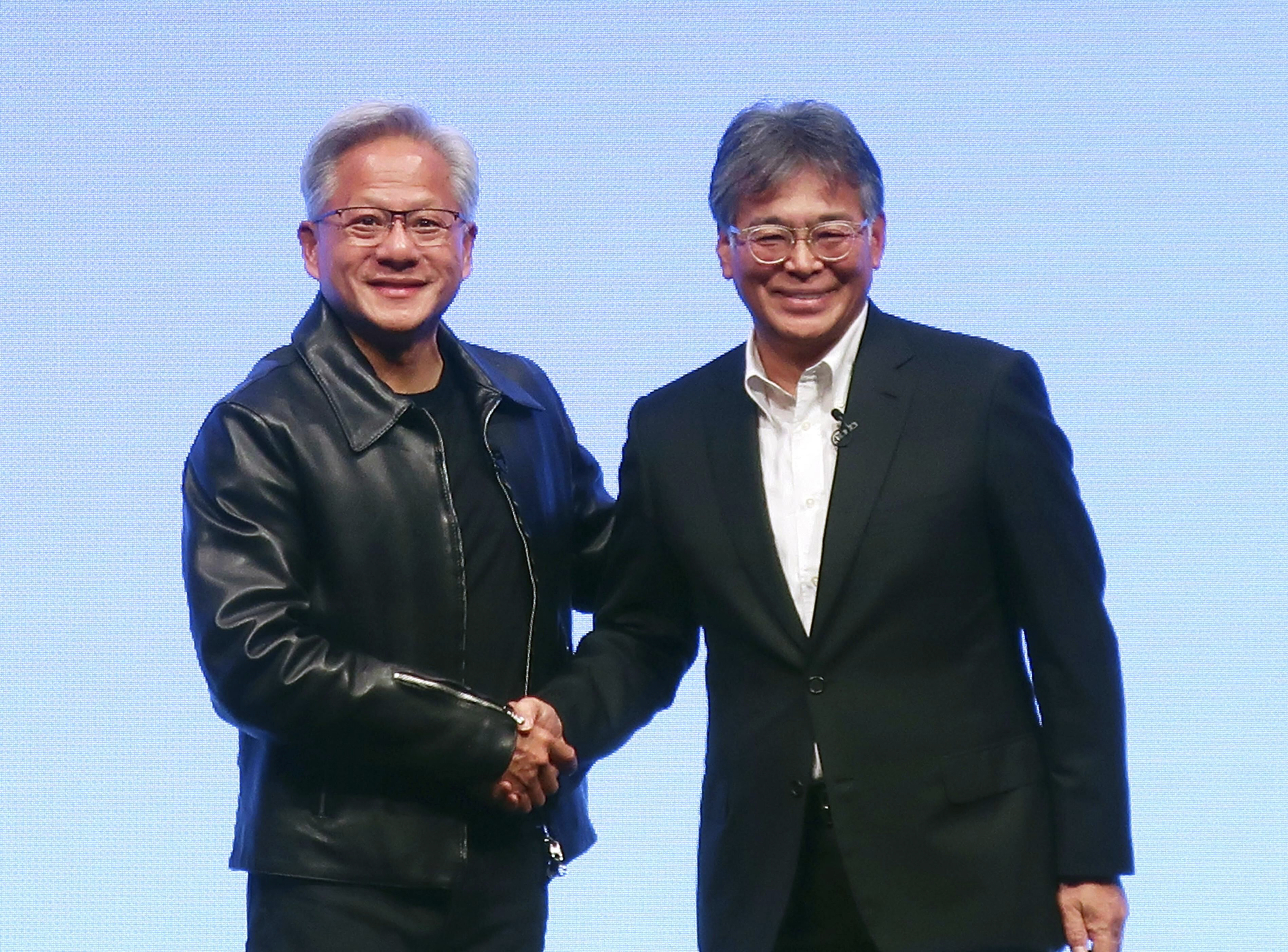 Nvidia Chief Executive Jensen Huang, left, and Fujitsu Chief Executive Takahito Tokita shake hands during an announcement in Tokyo Friday