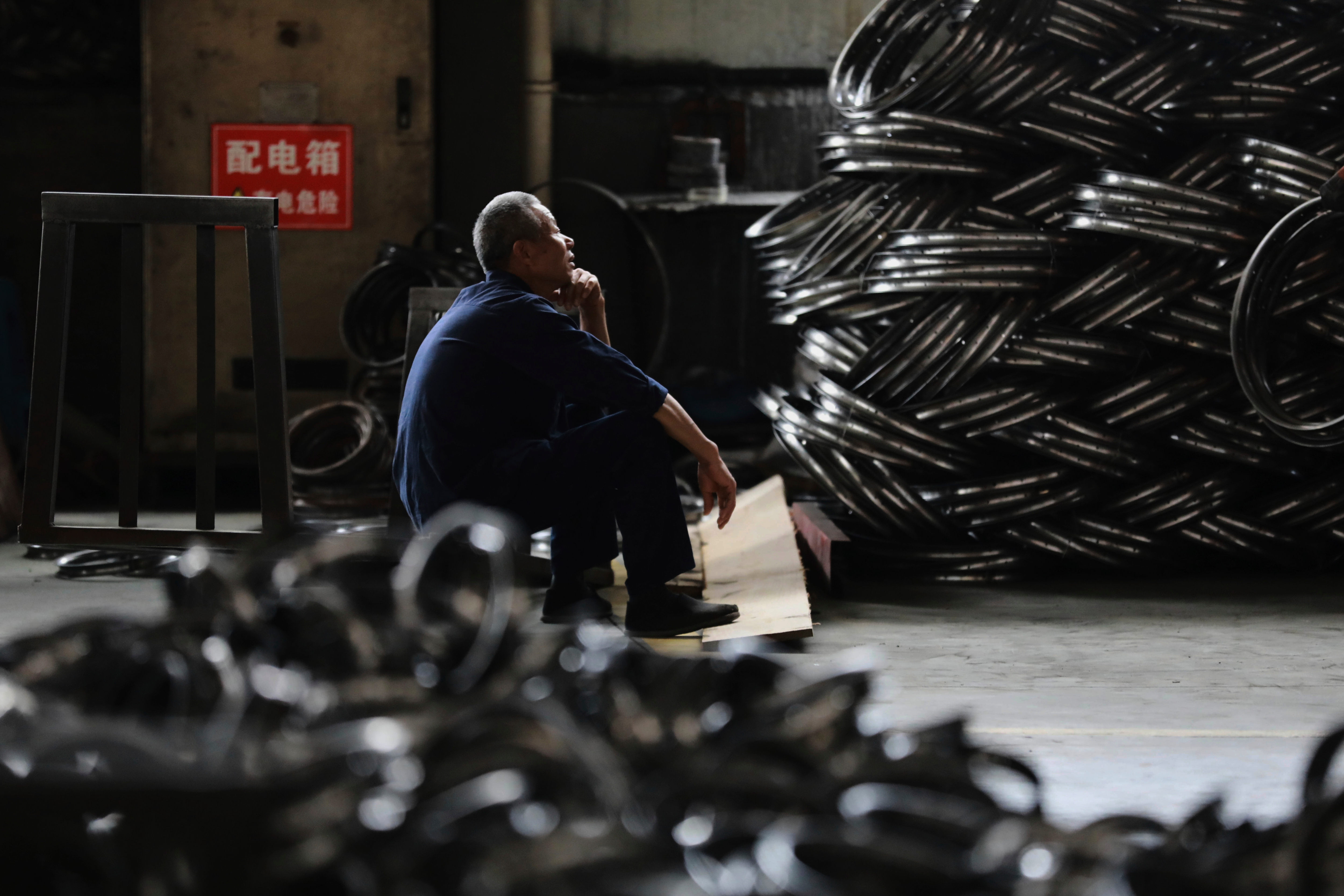 FILE - A worker takes a rest at a factory making steel bike rims for export to U.S., in Hangzhou in east China's Zhejiang province, on Friday, April 11, 2025. 