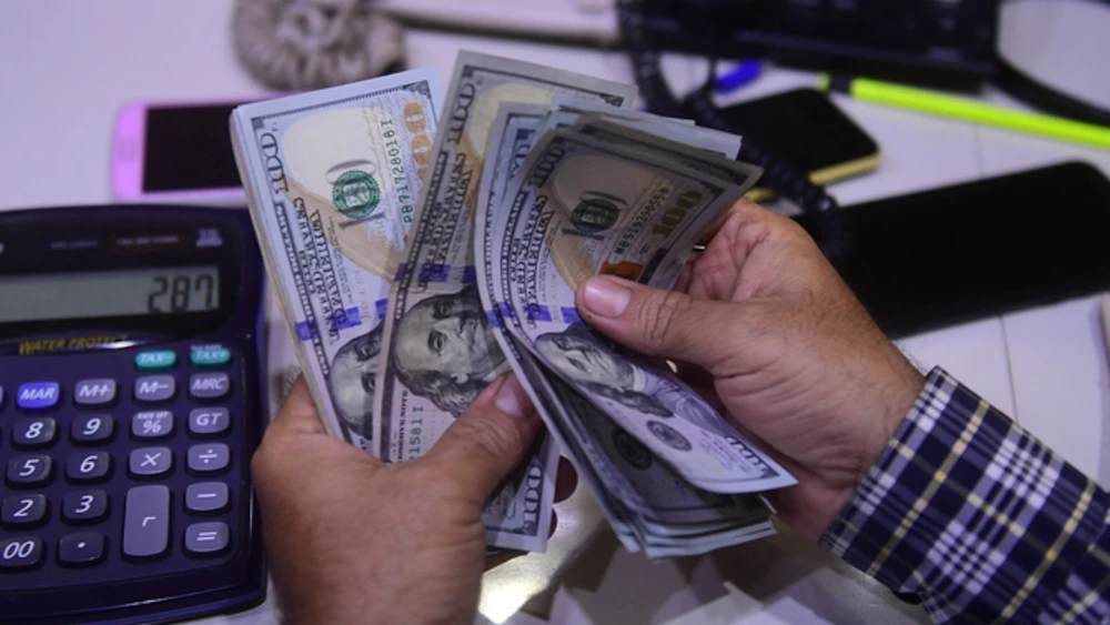 A dealer counts US dollars at a money exchange market in Karachi on March 2, 2023. (AFP/File)