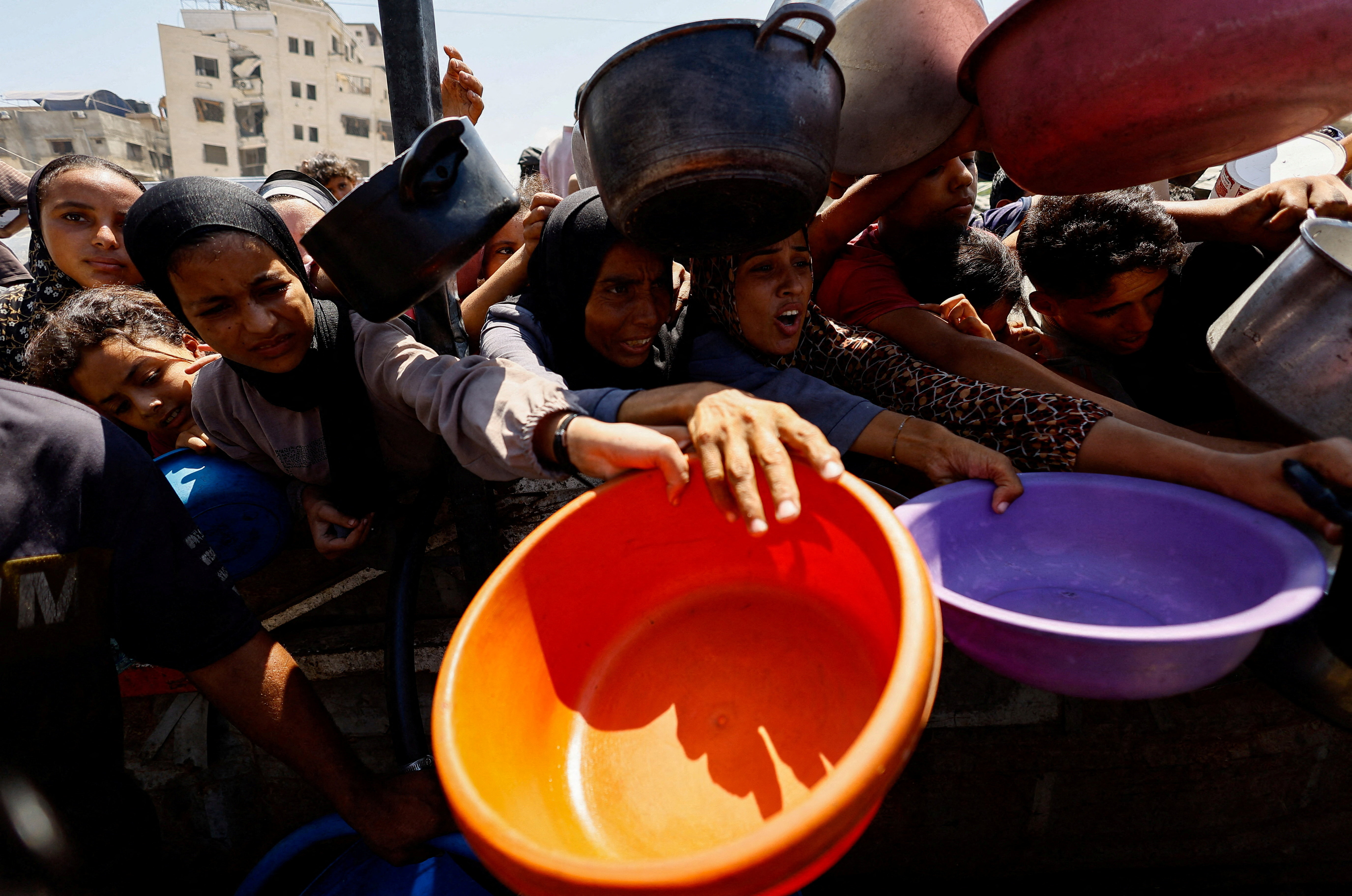 Palestinians wait for food at a charity kitchen in Gaza City