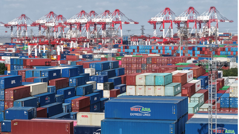 An aerial view shows stacked containers at the Shanghai Port container terminal in Shanghai on December 8, 2025. (Photo by AFP/File)