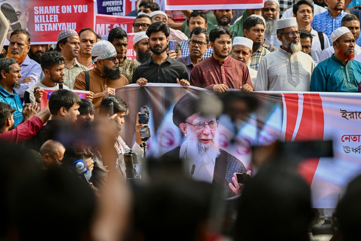 Activists and supporters of the Bangladesh Jamaat-e-Islami party hold posters of Iran's supreme leader Ayatollah Ali Khamenei during an anti-US and Israel protest at the Baitul Mukarram National Mosque in Dhaka on March 1, 2026. (AFP)