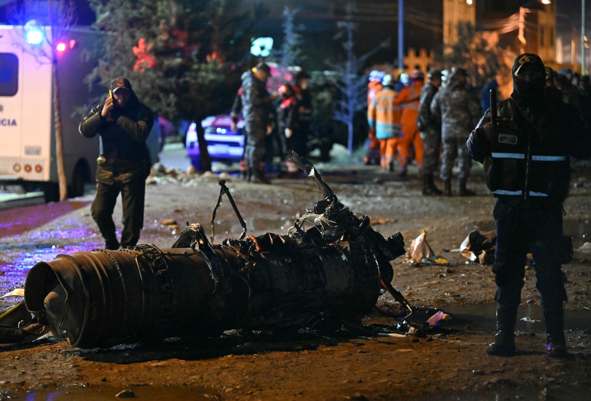 Military personnel stand next to pieces of a military plane that crashed in el Alto, near La Paz, on February 27, 2026. (Photo: AFP)